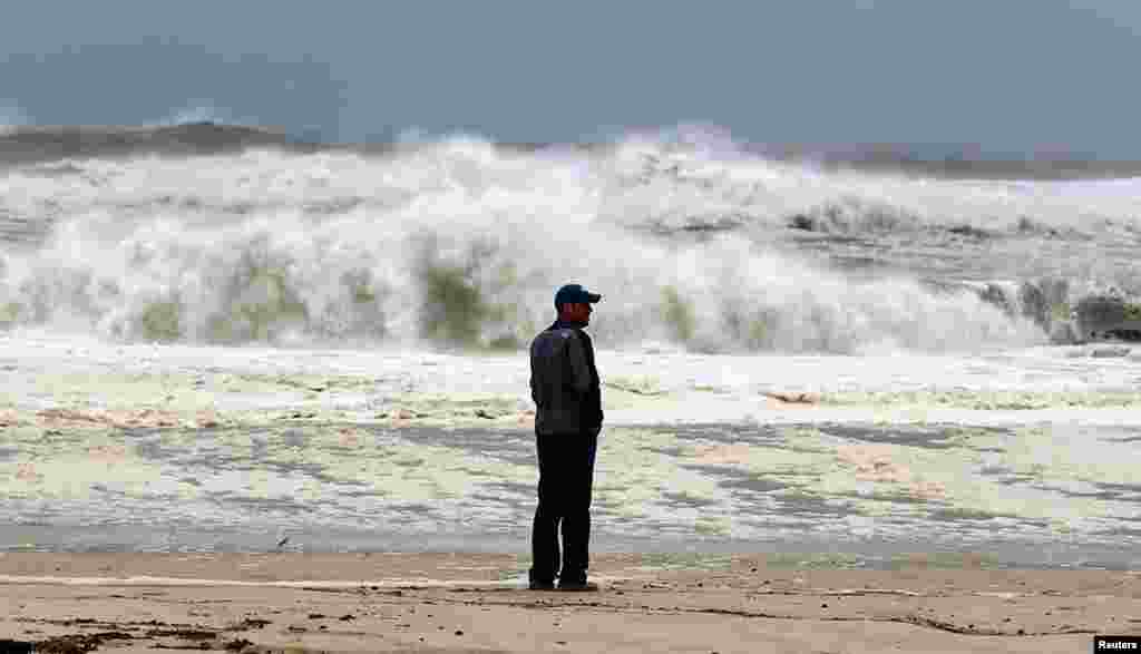 A man stands on the beach to watch the storm surf in Southampton, New York, October 29, 2012.