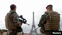 FILE - French army paratroopers patrol near the Eiffel tower in Paris, France, March 30, 2016. 