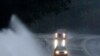 Varios automóviles avanzan por un camino con muchos charcos en Helena, Alabama, el viernes 25 de octubre. AP.
