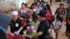 La gente recibe alimentos de Carolina Leal, directora y fundadora de la fundación Alimentando sueños, en Maracaibo, Venezuela, 12 de junio de 2024.