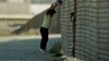 FILE - In this Oct. 14 1991 file photo, a group of illegal Mexican immigrants jump from a border fence to enter the United States, near Tijuana, Mexico.