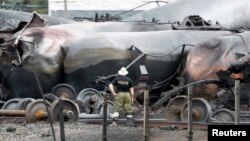 A police officer looks at the train wreckage in Lac-Megantic, July 9, 2013.