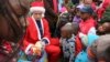 Wani mutum sanye da kayan Santa ya na raba kyaututtuka ga yara marasa galihu a wani yankin kasar Afrika ta Kudu. Dec. 25, 2016.