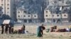 Người Palestine mang theo tư trang sau các cuộc không kích của Israel bắn trúng vào các tòa nhà dân cư tại Thành phố Hamad do Qatar tài trợ, ở Khan Younis ở phía nam Dải Gaza, ngày 2 tháng 12 năm 2023.