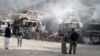 Afghan police stand guard near burning NATO supply trucks following an attack by militants on a U.S. base near the Pakistan-Afghanistan border, Sept. 2, 2013. 