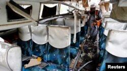 A rescue worker collects evidence from a damaged bus after it was hit by a bomb attack on the outskirts of Peshawar, Pakistan, Sept. 27, 2013. 