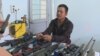 Nguyễn Quốc Thắng cùng tang vật là các khẩu súng tự chế. (Ảnh chụp màn hình ZingNews)