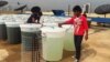 Energaia workers inspect some of the bio-reactors growing spirulina on the rooftop of a Bangkok hotel, Sept. 24, 2013. (S.L. Herman/VOA)