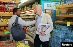 Jeremy Corbyn, leader of Britain's opposition Labour Party, holds newspapers and greets a passer by in Islington, London, Britain June 10, 2017.