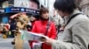 A Japanese tourist (R) speaks to a volunteer interpreter in Central Seoul April 8, 2013.