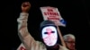 A Boeing worker wears a mask with a digital "strike" sign as employees picket after union members voted overwhelmingly to reject a contract offer and go on strike Sept. 13, 2024, outside the company's factory in Renton, Washington. 