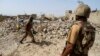 FILE - Pakistani soldiers stand near the debris of a house which was destroyed during a military operation against Taliban militants in the town of Miranshah in North Waziristan, July 9, 2014. 