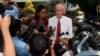 Alan Morison (R), an Australian, and Thai national Chutima Sidasathian, reporters for the Phuketwan news website, speak to media as they arrive to a criminal court in Phuket, April 17, 2014. 