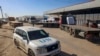 Mobil PBB melewati truk pengantar bantuan kemanusiaan yang memasuki Gaza melalui perbatasan Kerem Shalom (Karm Abu Salem) di bagian selatan wilayah Palestina, di Rafah, Jalur Gaza selatan, 17 Februari 2024. (SAID KHATIB/AFP)