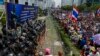 Anti-government protesters gather as Thai soldiers stand guard at a Defense Ministry compound serving as a temporary office for Thai Prime Minister Yingluck Shinawatra in north Bangkok, Feb. 19, 2014. 