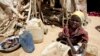 FILE - A young girl washes clothes outside her shack at the Iridimi refugee camp near Iriba in eastern Chad, Sept. 25, 2004. 