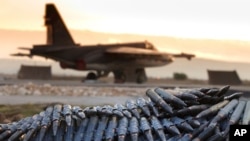 FILE - In a Dec. 18, 2015, photo, provided by the Russian Defense Ministry's Press Service, a load of ammunition is being prepared to be loaded onto a Russian war plane at Hmeymim air base, in Syria.