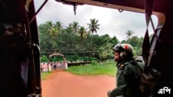 ভারতীয় নৌবাহিনীর দেয়া ছবিতে দেখা যাচ্ছে কেরালার বন্যা কবলিতদের মধ্যে ত্রাণ বিতরণের প্রস্তুতির আগে হেলিকপ্টার থেকে পর্যবেক্ষণ করছেন নৌবাহিনীর একজন সদস্য- অক্টোবর ১৭, ২০২১- এপি 