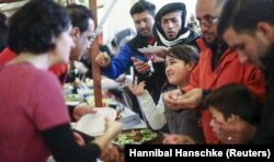 Berlin'de bir hayır kurumu tarafından işletilen Noel pazarında yiyecek yardımı alan sığınmacılar
