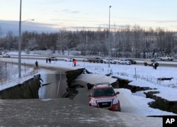 Un auto queda atrapado en una sección colapsada de la rampa de salida de Minnesota Drive en Anchorage, el viernes 30 de noviembre de 2018.