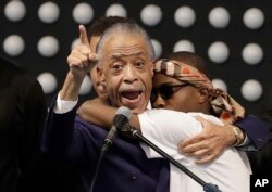 FILE - Rev. Al Sharpton, left, hugs Stevante Clark while speaking during the funeral services for police shooting victim Stephon Clark at Bayside Of South Sacramento Church in Sacramento, California, March 29, 2018.