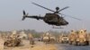 U.S. troops assess the damage to an armored vehicle of NATO-led International Security Assistance force at the site of a suicide attack in Jalalabad province, Aug. 24, 2014. 