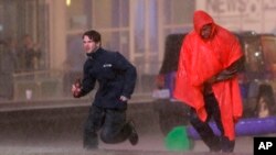 Gente busca cubrirse de una torrencial lluvia en el centro de Dallas, Texas.
