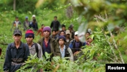 FILE PHOTO - Montagnard hill tribesmen walk towards the main road after emerging from dense forest 70 km (43 miles) northeast of Ban Lung, located in Cambodia's northeastern province of Ratanakiri July 22, 2004. 