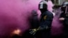Policías catalanes son envueltos en el humo de las bombas lanzadas por los seguidores de Puigdemont en Barcelona.