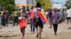 Un migrante lleva una bandera venezolana en Necoclí, Colombia, un punto de parada para los migrantes que toman barcos hacia Acandí que conducen al Tapón del Darién, el jueves 13 de octubre de 2022.