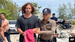 A Thai police officer escorts Daniel Sancho Bronchalo to Koh Samui Provincial Court in Samui, Thailand, on Aug. 7, 2023. The court on Aug. 29 found Sancho guilty of premeditated murder and sentenced him to life in prison.