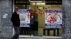 Man passes entrance of a store that buys gold vandalized with Greek word "thievess," Nicosia, Cyprus, March 25, 2013.