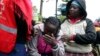 Kenya Red Cross personnel and relatives try to comfort a woman reacting near a burned-out dormitory, following a fire at the Hillside Endarasha Primary in Nyeri, Kenya, Sep. 6, 2024. 