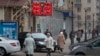 FILE - People walk past a currency exchange rate display in central Moscow, Dec. 1, 2014.