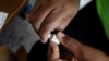 FILE - A member of the vaccination campaign against cholera opens a vial at the Immaculate Conception Hospital in Les Cayes, Haiti, Nov. 8, 2016. 