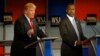 Donald Trump speaks as Ben Carson listens during the Republican presidential debate at the Milwaukee Theatre, Nov. 11, 2015, in Milwaukee
