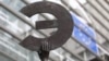 A statue shows the Euro symbol flipped, at the European Commission headquarters in Brussels, Belgium, March 7, 2012. 