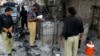 Policemen collect evidence outside a prison following a Taliban attack in Dera Ismail Khan, Pakistan, July 30, 2013. 