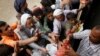 FILE - People gather to collect food rations at a food distribution center in Sana'a, Yemen, March 21, 2017.
