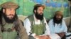 FILE - Pakistani Taliban spokesman Shahidullah Shahid, center, flanked by bodyguards, talks to reporters at undisclosed location, Pakistani tribal area of Waziristan, Oct. 5, 2013.