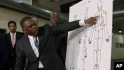 Pathologist, Dr. Bennet Omalu, gestures in front of a diagram showing the gun shot wounds he found on the body of police shooting victim Stephon Clark, during a news conference, March 30, 2018, in Sacramento, California.