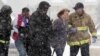 Two women are evacuated from a Colorado Springs, Colorado building where a shooter was suspected to be holed up November 27, 2015.