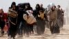 People walk with their belongings as they flee the rebel-held town of Hammouriyeh, eastern Ghouta, Syria, March 15, 2018.