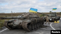 Військовослужбовці ЗСУ поряд із захопленими російськими танками, Ізюм, Харківщина, 19 вересня 2022. REUTERS/Gleb Garanich