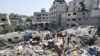 Des Palestiniens portent le corps d'une personne tuée lors d'une frappe israélienne sur une maison, dans le camp de réfugiés de Jabalia, dans le nord de la bande de Gaza, le 18 mai 2024. (REUTERS/Rami Zohod)