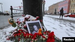 Potret blogger militer Rusia Vladlen Tatarsky, (nama asli Maxim Fomin), yang tewas dalam ledakan kafe sehari sebelumnya, ditempatkan di antara bunga dekat lokasi ledakan di Saint Petersburg, Rusia 3 April 2023. (REUTERS/Anton Vaganov)