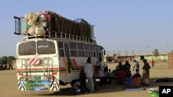 Southern Sudanese from Abyei, who have resided in the north for 21 years, wait next to a bus which will transport them back to the Abyei oil region, in Khartoum (File Photo)