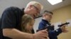 Instructor Jerry Kau shows student Joanna Zuber how to load a magazine into a handgun alongside Sam Minnifield during a Youth Handgun Safety Class at GAT Guns in East Dundee, Illinois, April 21, 2015.