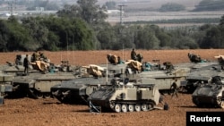 Des soldats israéliens debout sur des véhicules blindés de transport de troupes dans une zone de rassemblement près de la frontière avec Gaza, dans le sud d'Israël, le 13 novembre 2019. REUTERS / Ammar Awad