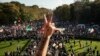 Seorang pria memberi isyarat dengan dua jarinya saat berlangsungnya aksi protes terhadap rezim Iran, di Berlin, Jerman, 22 Oktober 2022, menyusul kematian Mahsa Amini dalam tahanan "polisi moral" republik Islam yang terkenal itu.